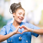 Young nurse showing heart sign