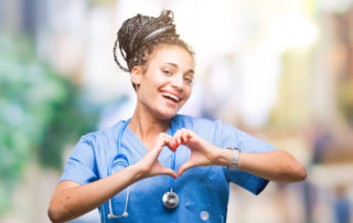 Young nurse showing heart sign